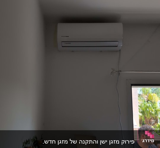 מזגן מותקן על קיר עם כבל חשמל מחובר
